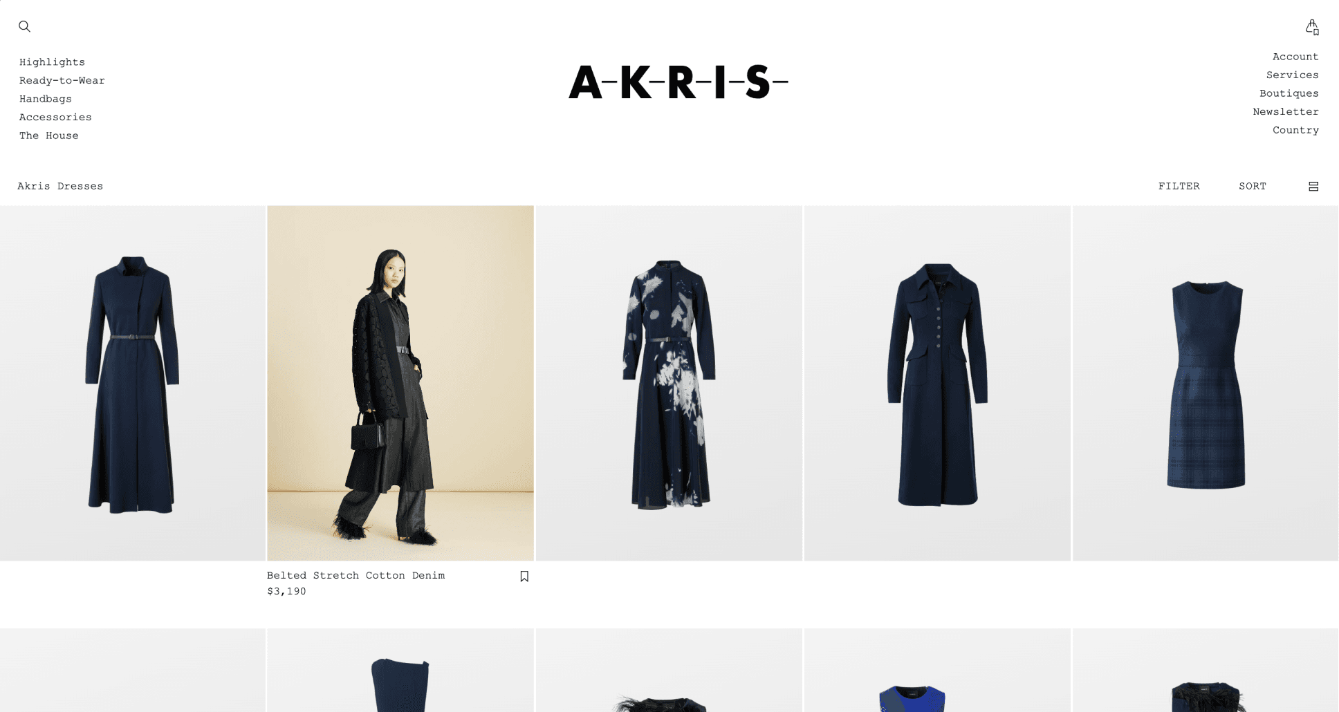 Website showcasing women's fashion, featuring a grid of blue and black dresses, with a model wearing a belted coat on the left.