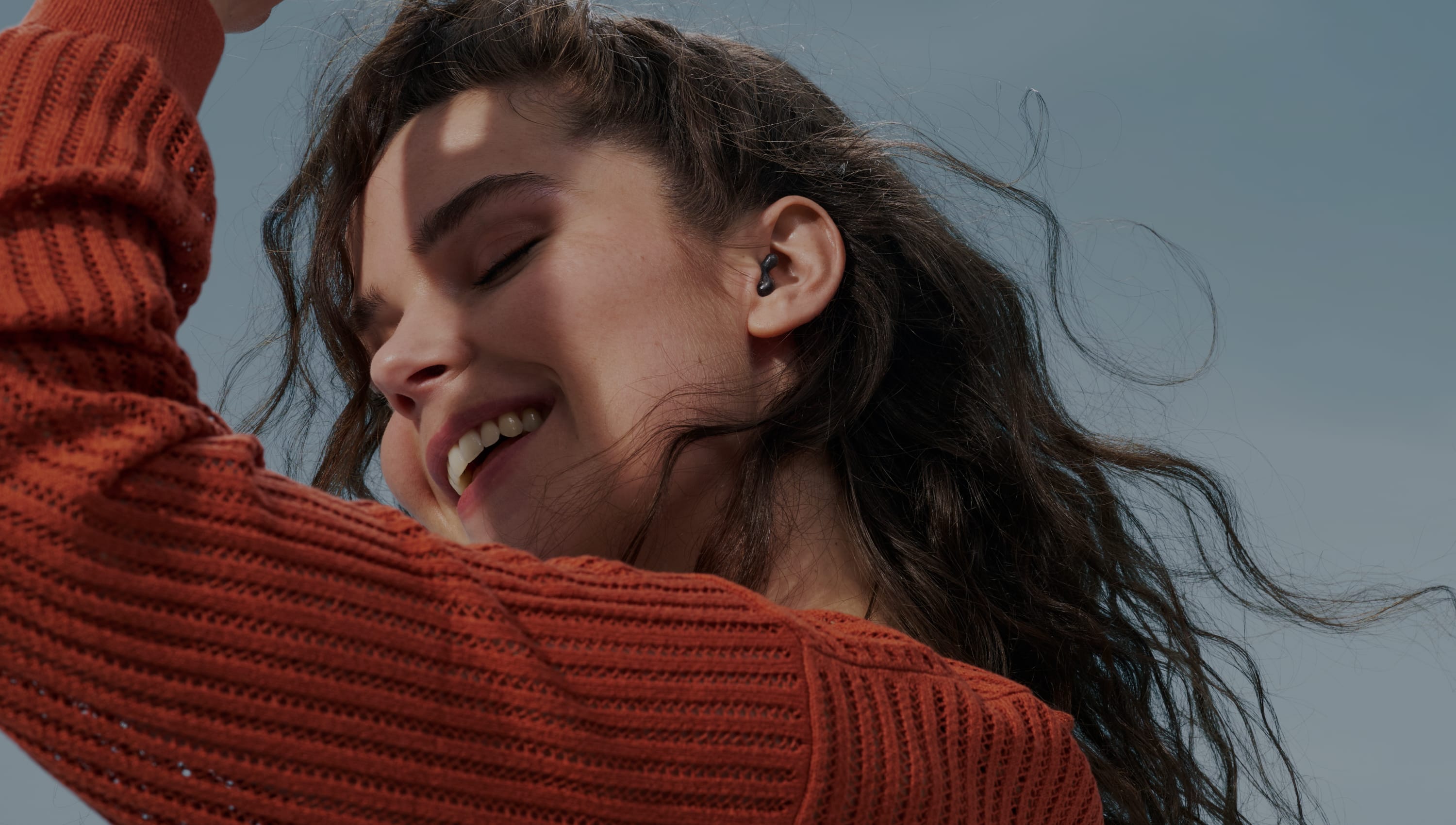 Woman dancing while wearing Alpine earplugs