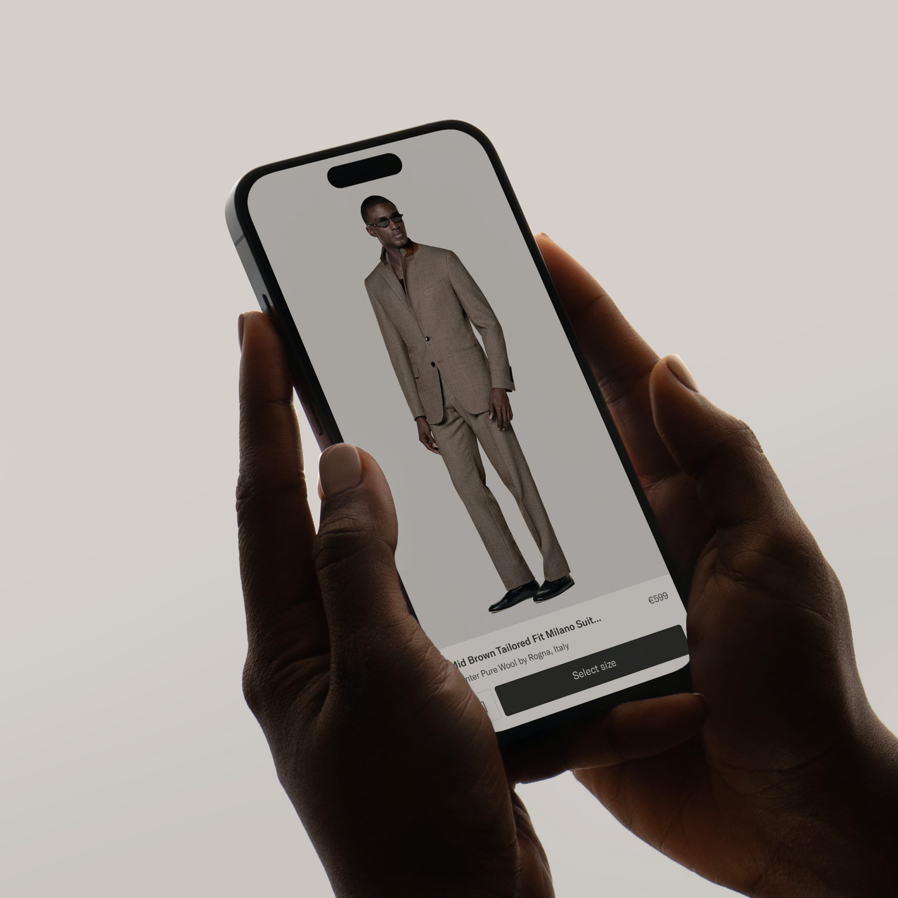 Hands holding a smartphone displaying a beige tailored suit model on a shopping app, with a price of €599 shown.