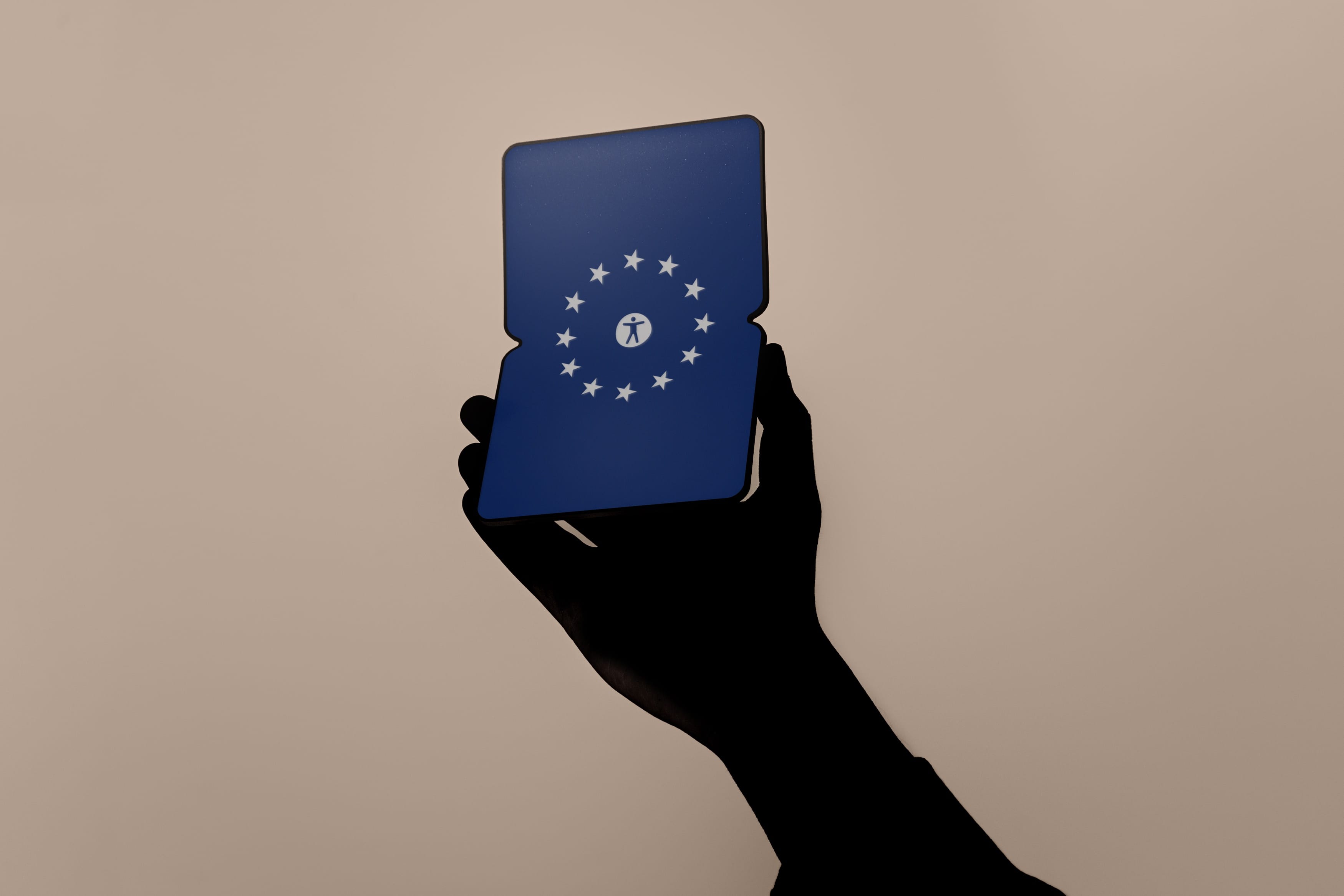 A hand holds a foldable touch device displaying the European flag and the symbol of a human in white.
