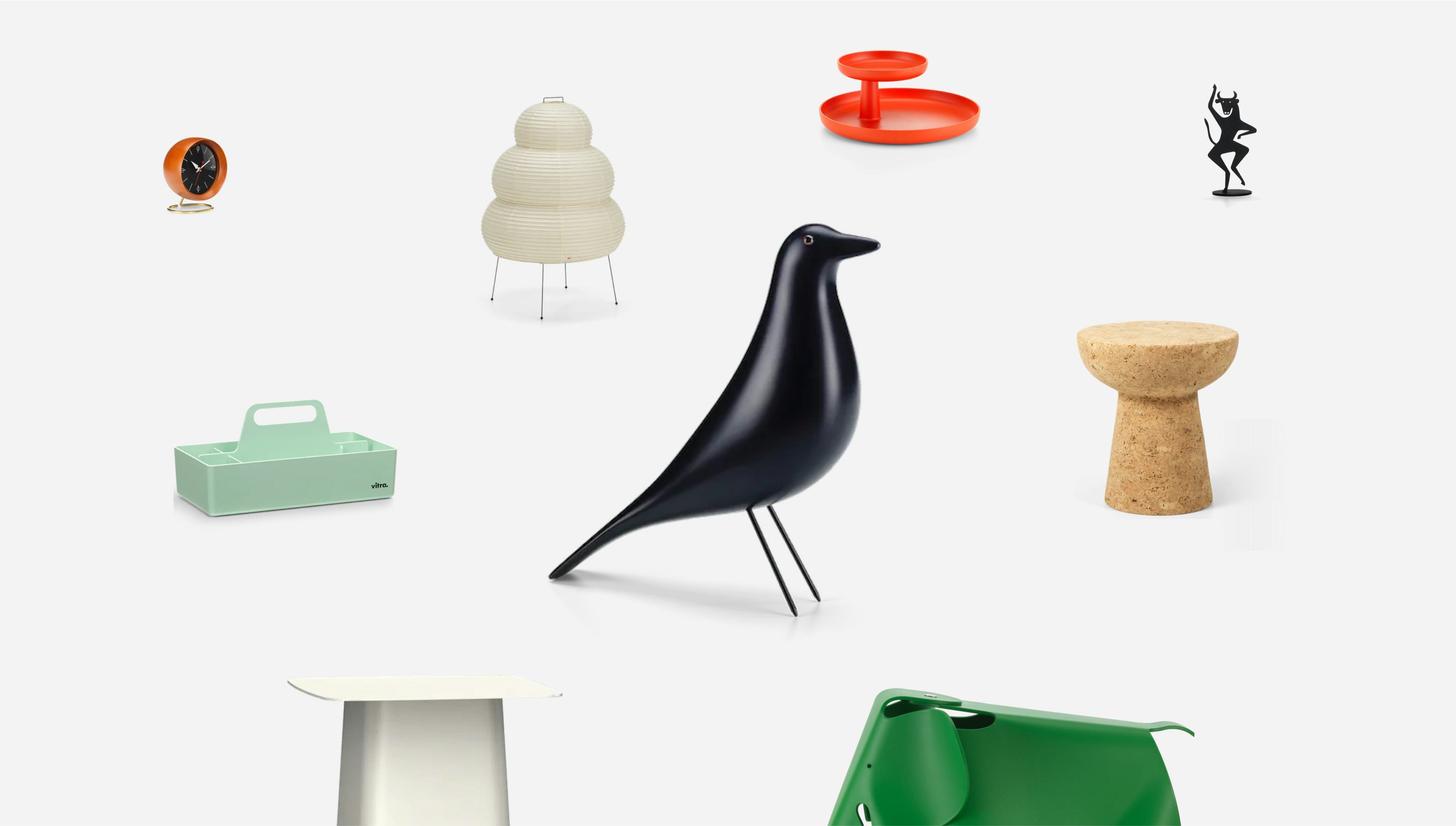 Objects and gifts from the Vitra Gift Finder website. There is a wooden bird in the middle, surrounded by a cork stool, an elephant, sculptures, a clock and a small table.